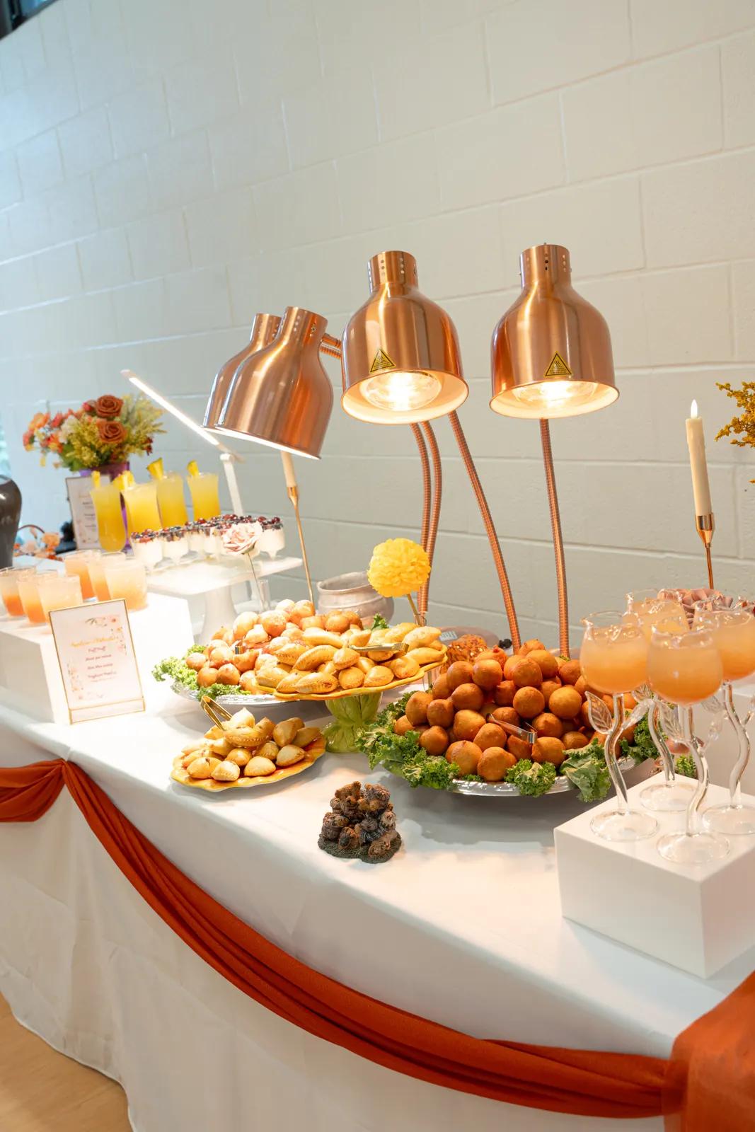 A TFL event table with pastries and drinks under copper lamps